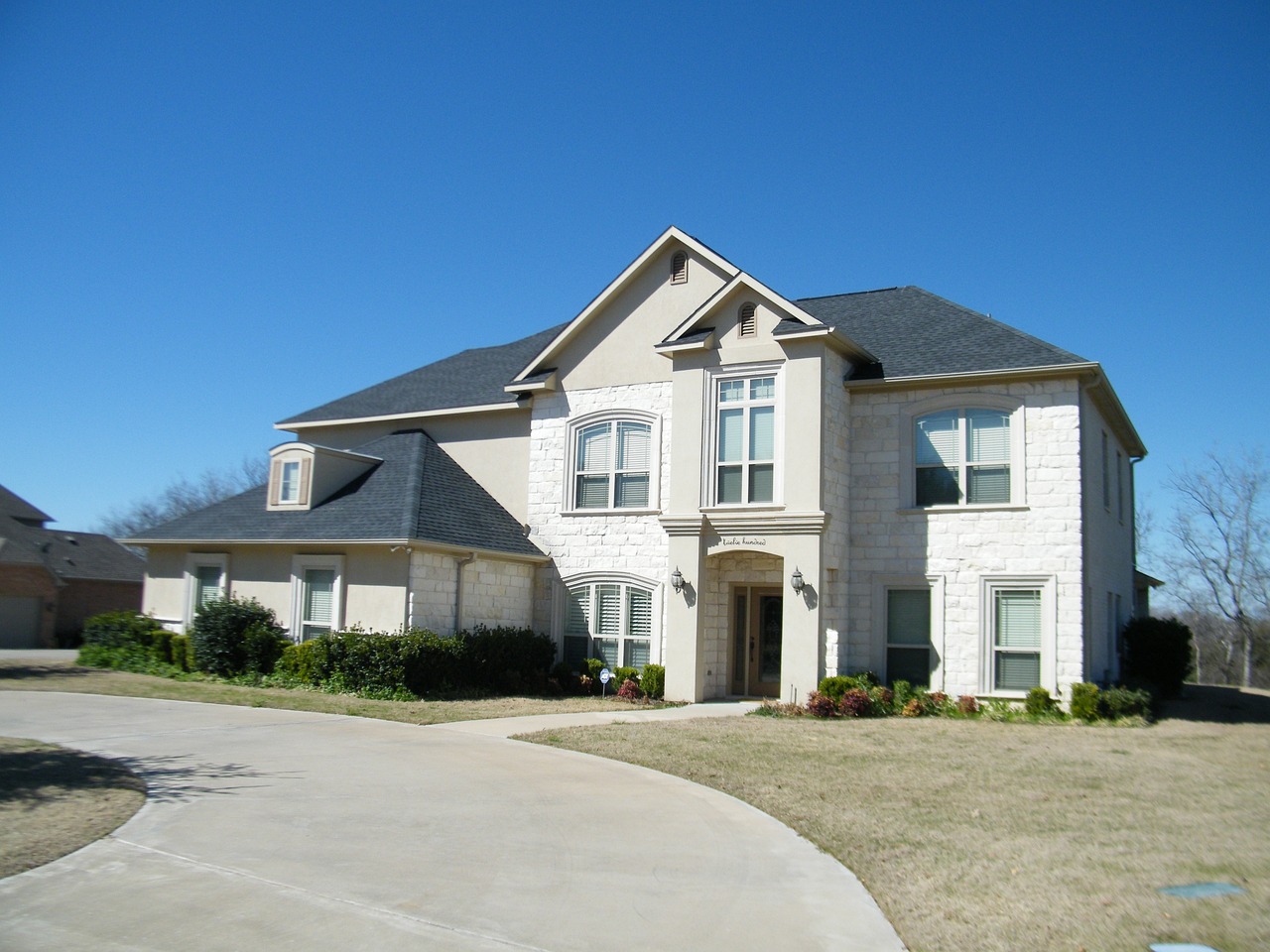 white brick home, blue sky, driveway-291661.jpg
